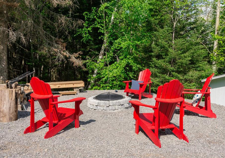 A ring of Muskoka chairs around an attractive fire pit.